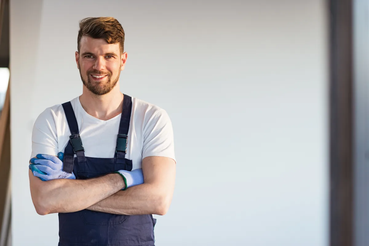Technician in dark overalls standing indoors
