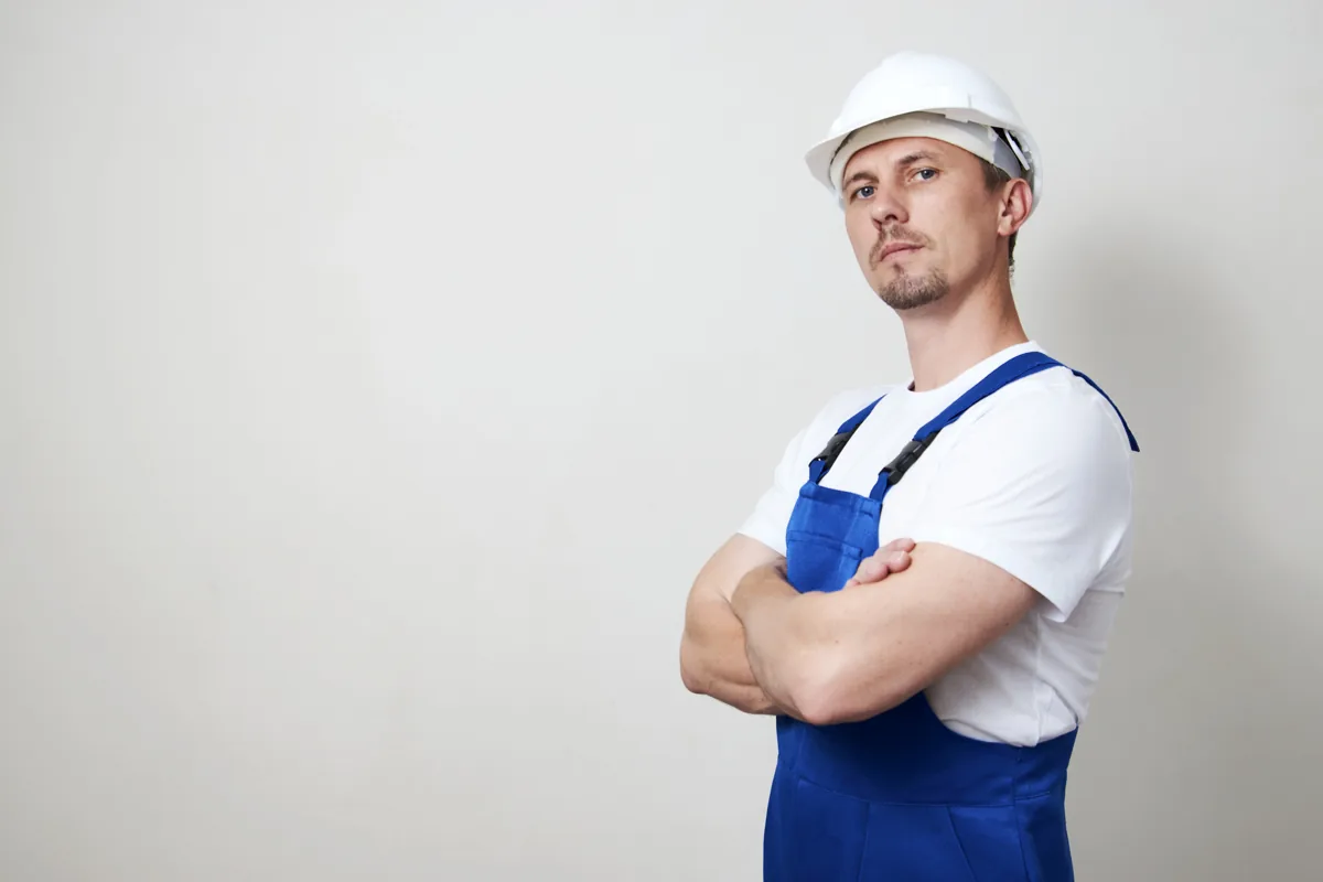 Technician wearing a hard hat with arms folded